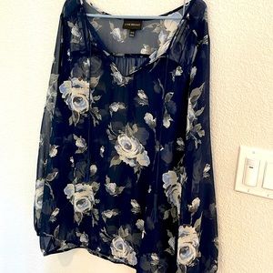 This women’s sheer over shirt is a blue floral print with long sleeves